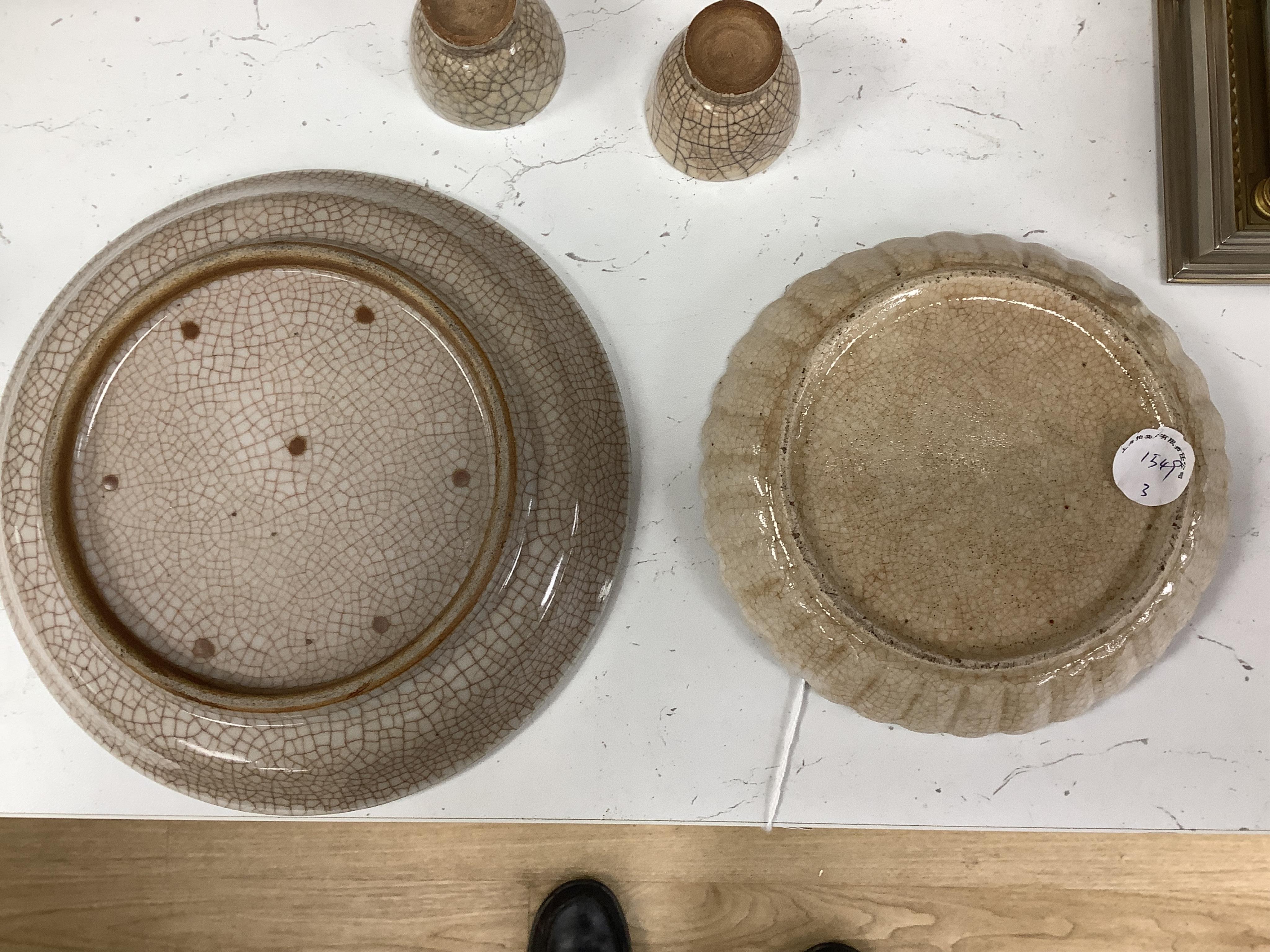 A Chinese crackle glaze chrysanthemum shaped dish, two cups and an underglaze blue dish, 19th century and later, blue dish 21cm diameter (4). Condition - fair